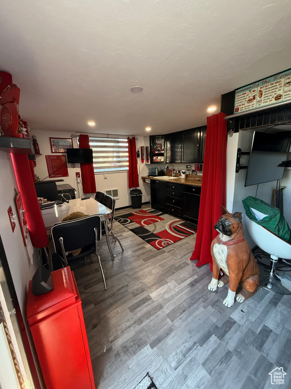 Kitchen with wood finished floors, a sink, and light countertops