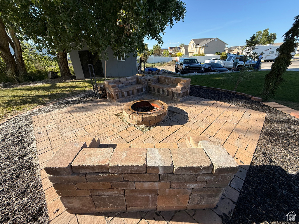 View of patio with a residential view, a fire pit, and an outdoor structure
