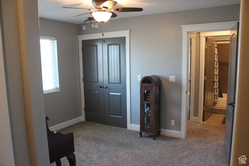 Entryway with ceiling fan, plenty of natural light, carpet floors, and baseboards
