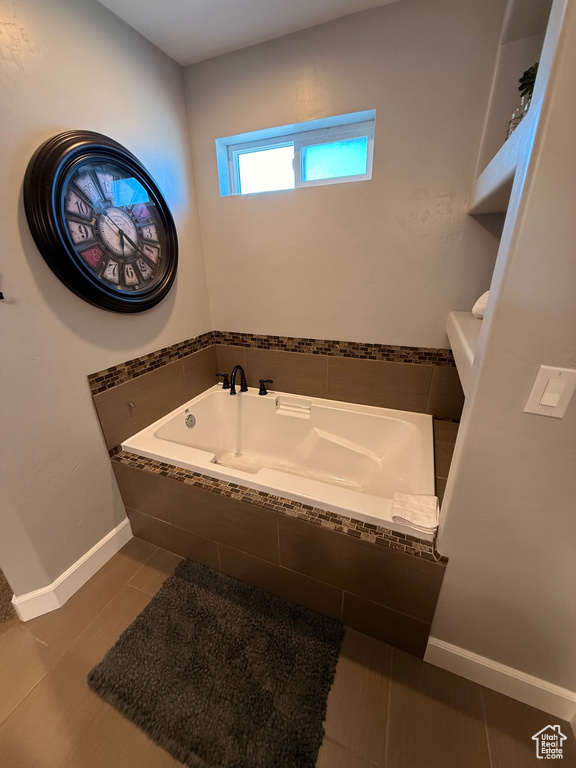 Bathroom with a bath, baseboards, toilet, and tile patterned flooring