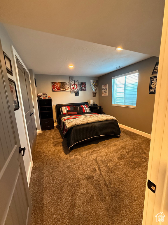 Bedroom with dark colored carpet, recessed lighting, and baseboards