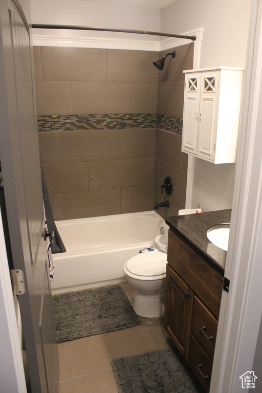 Bathroom with washtub / shower combination, vanity, toilet, and tile patterned floors