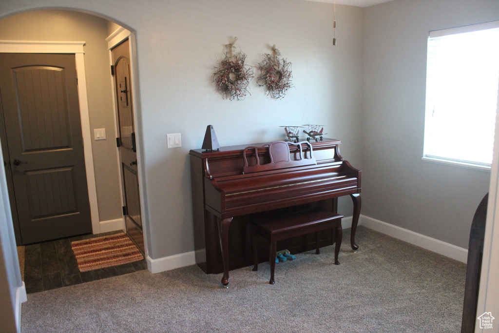 Living area with arched walkways, carpet floors, and baseboards