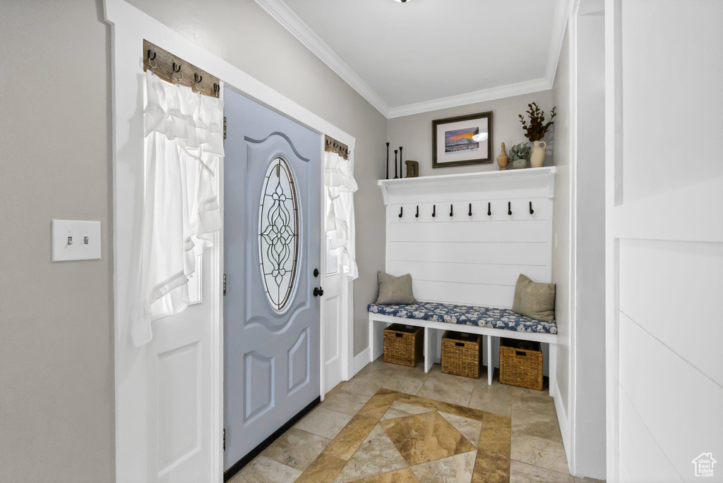 Mudroom featuring crown molding and baseboards