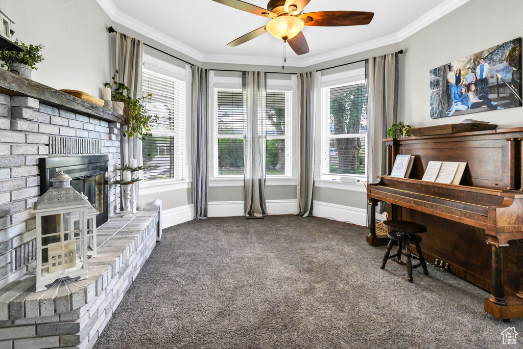 Sitting room featuring ornamental molding, carpet flooring, healthy amount of natural light, ceiling fan, and baseboards