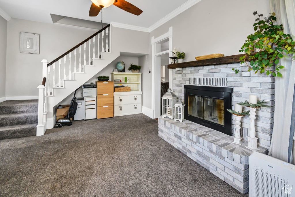 Unfurnished living room with stairs, carpet, baseboards, ceiling fan, and a fireplace