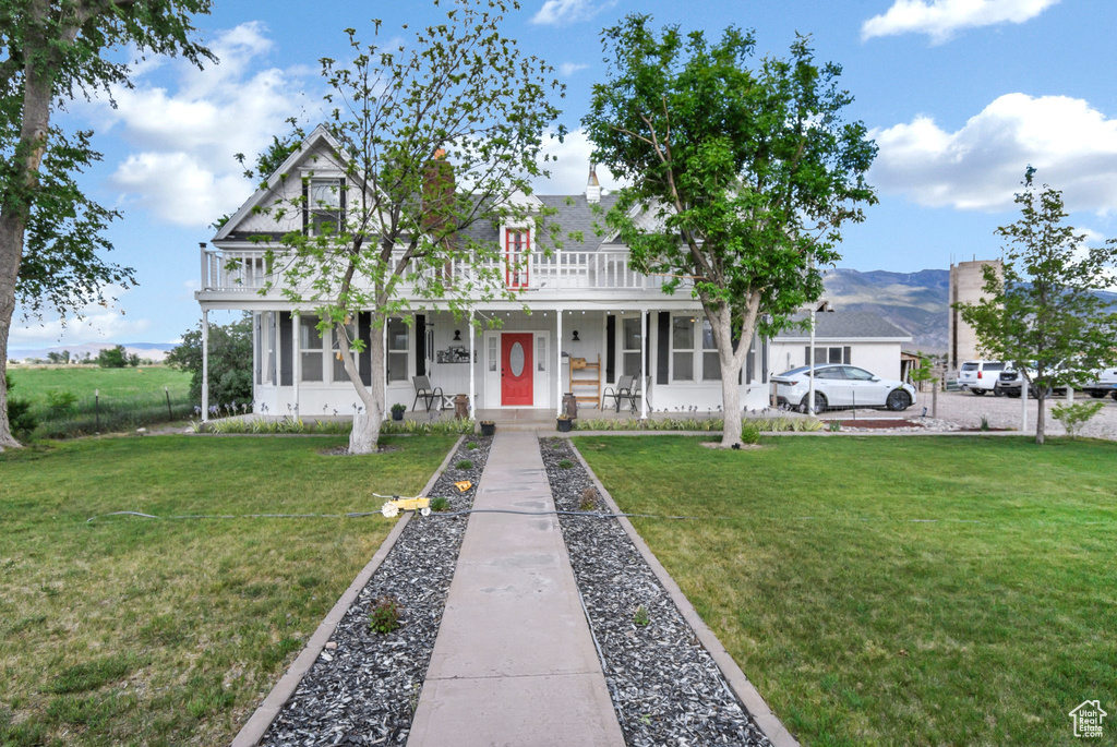 View of front facade featuring a front yard and a porch