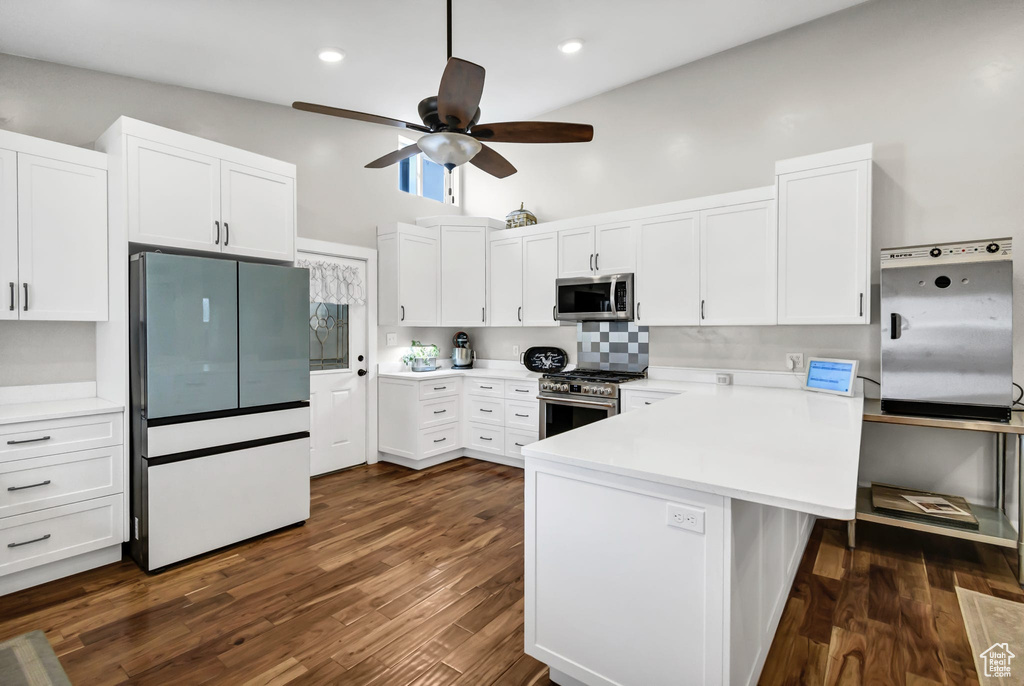 Kitchen featuring stainless steel appliances, a peninsula, a ceiling fan, white cabinets, and recessed lighting