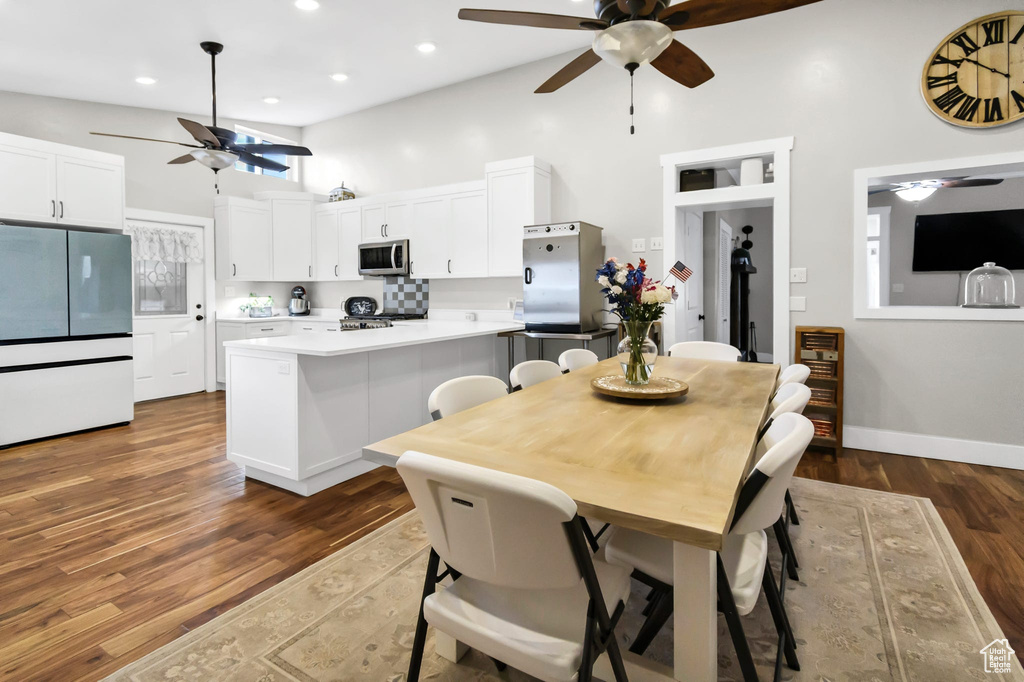 Dining room featuring ceiling fan, high vaulted ceiling, dark wood-style floors, recessed lighting, and baseboards