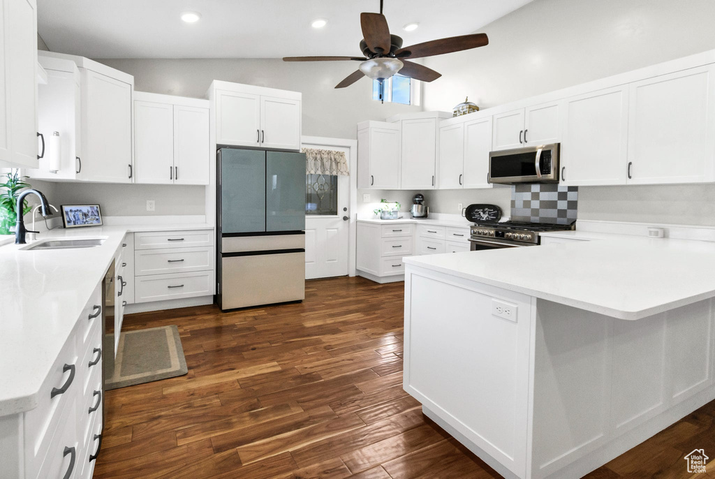 Kitchen with stainless steel appliances, a sink, ceiling fan, a peninsula, and light countertops