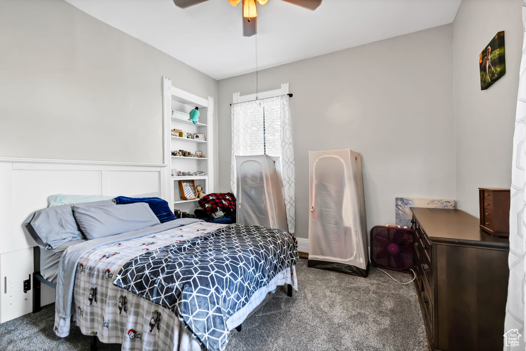 Carpeted bedroom with a ceiling fan