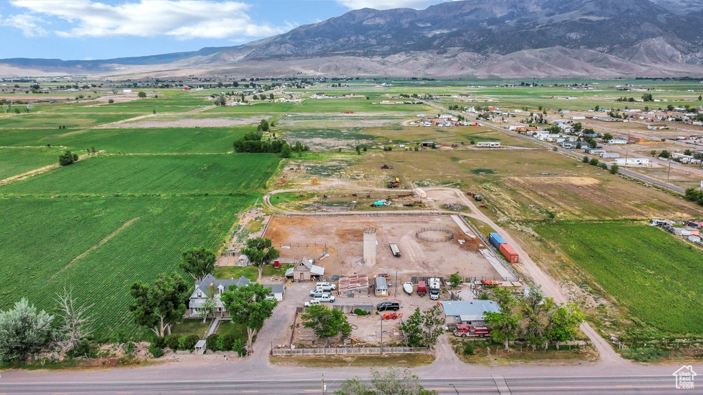 Aerial view of property and surrounding area featuring rural landscape and a mountainous background