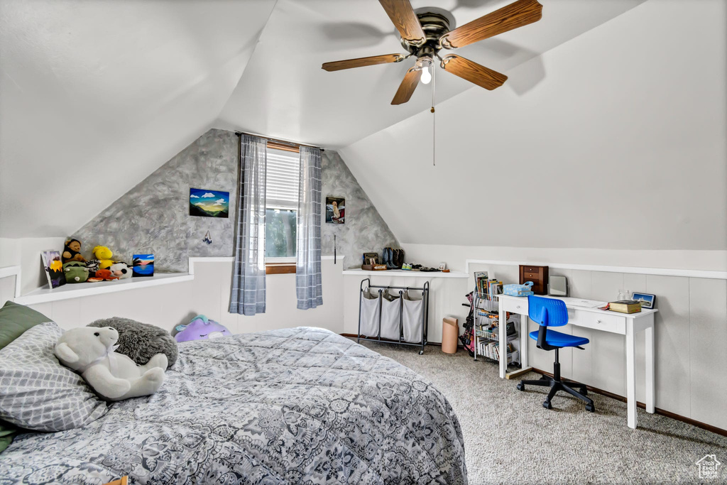 Carpeted bedroom with vaulted ceiling and a ceiling fan