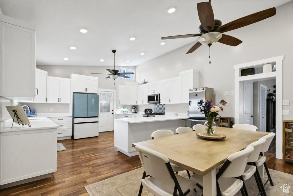 Dining space featuring ceiling fan, high vaulted ceiling, dark wood finished floors, and recessed lighting
