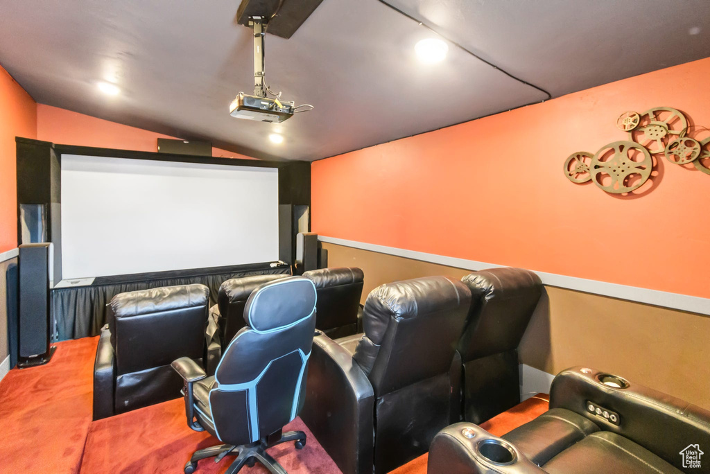 Home theater featuring lofted ceiling and carpet floors