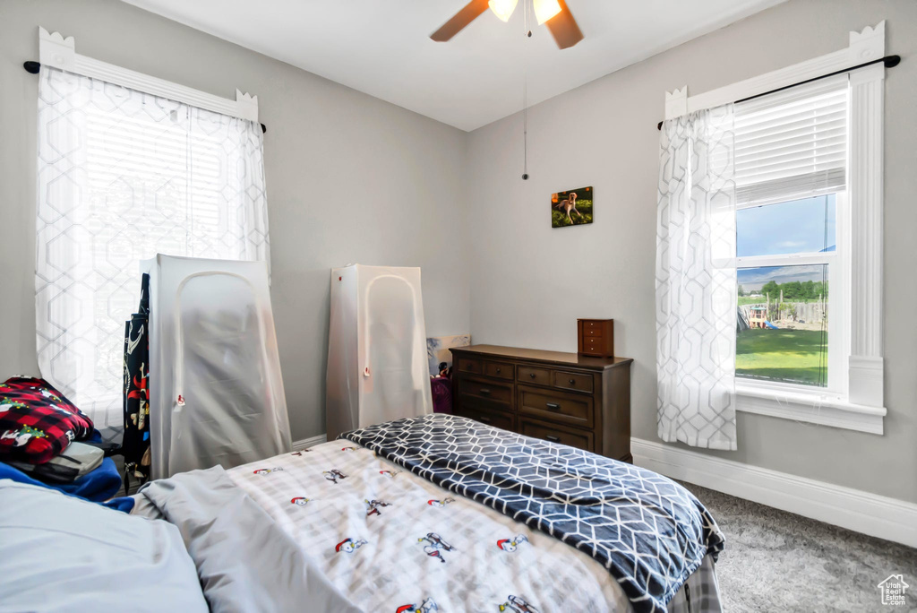 Carpeted bedroom featuring baseboards and ceiling fan