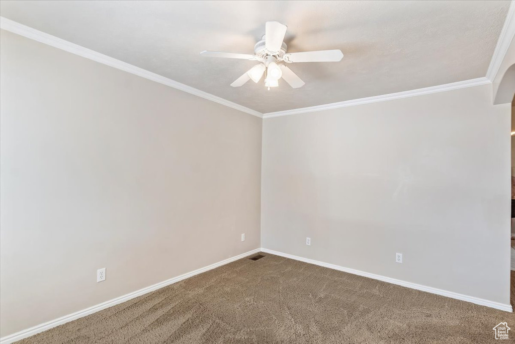 Unfurnished room with ceiling fan, ornamental molding, carpet, and baseboards