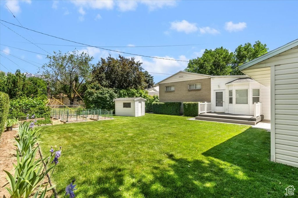 View of yard featuring a wooden deck and a vegetable garden