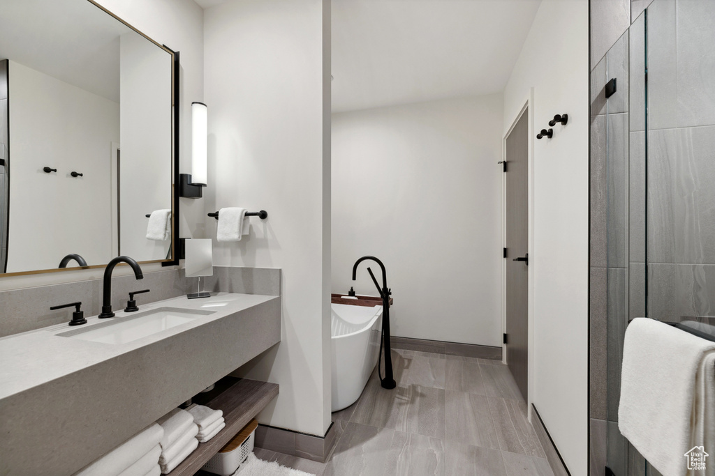 Bathroom with a freestanding bath, vanity, and baseboards