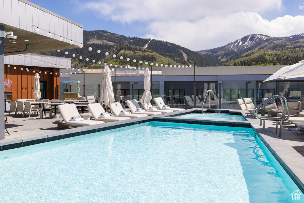 Community pool featuring a mountain view, a community hot tub, and a patio