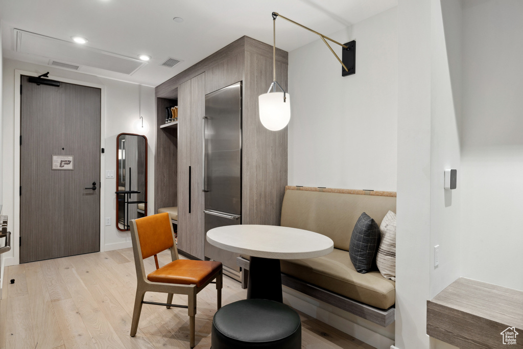 Dining space featuring light wood finished floors, recessed lighting, and arched walkways