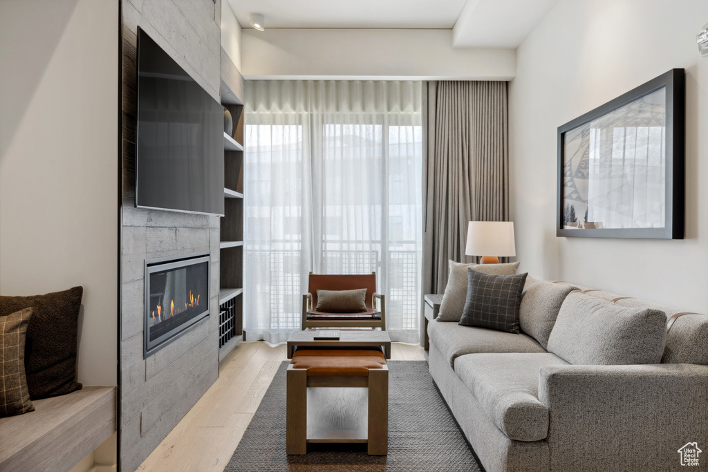 Living area featuring wood finished floors and a large fireplace