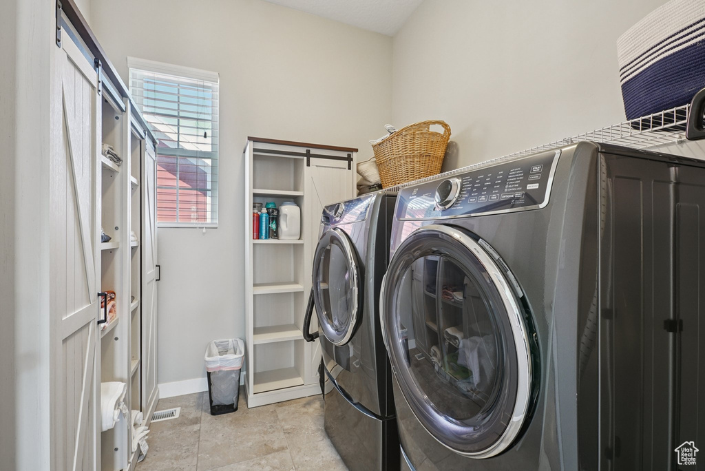 Laundry room with separate washer and dryer and baseboards