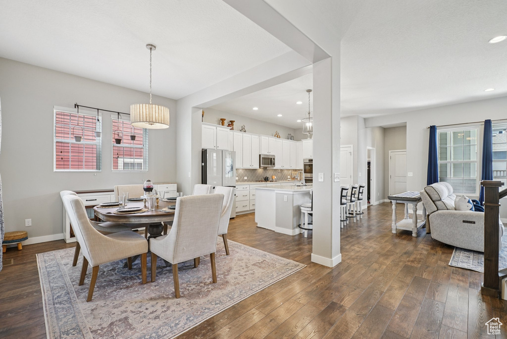 Dining area with dark wood finished floors, recessed lighting, and baseboards