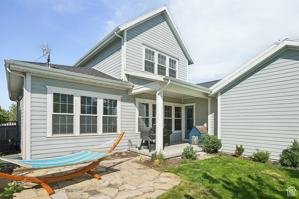 Rear view of house with a patio, a yard, and central AC unit