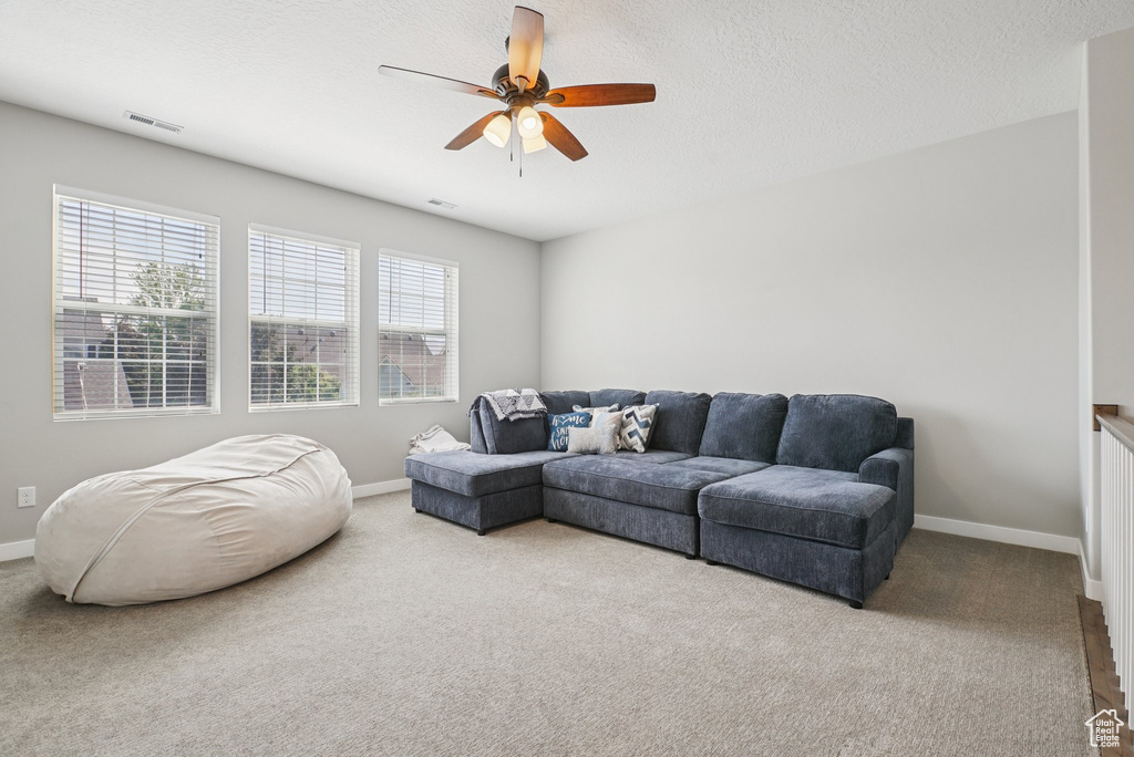 Living room featuring carpet, baseboards, and a ceiling fan