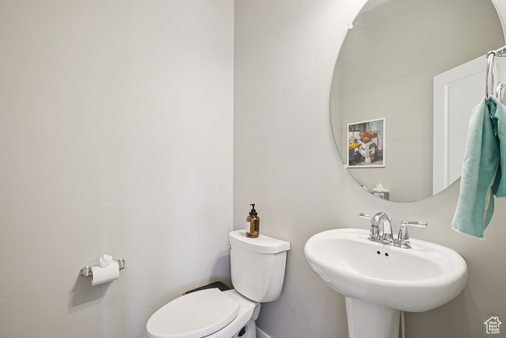 Bathroom with toilet, a sink, and baseboards