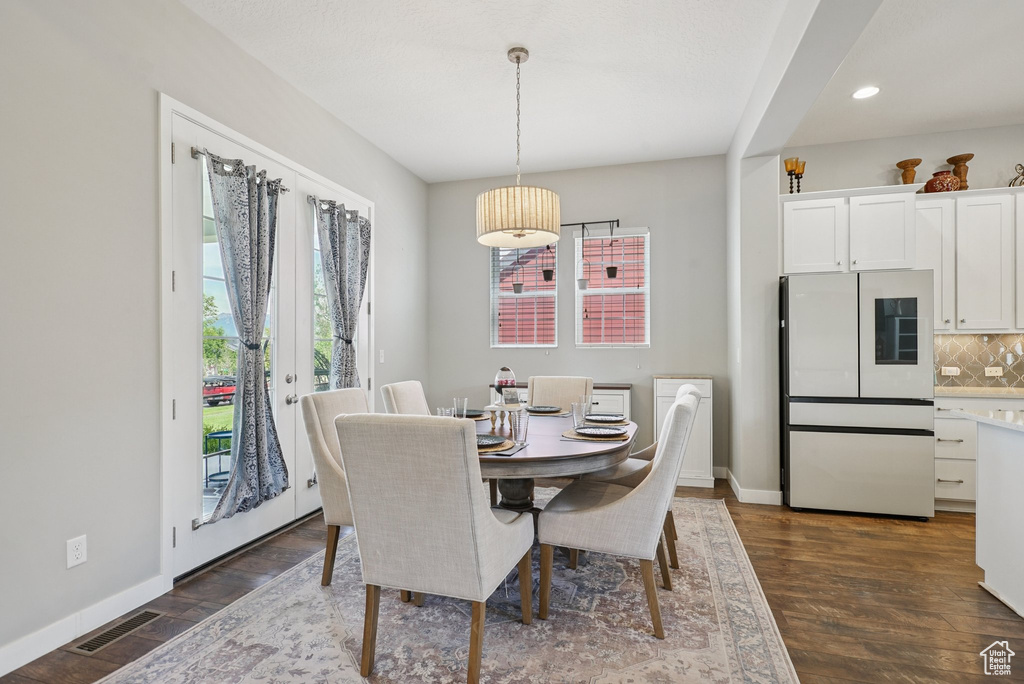 Dining room with plenty of natural light, dark wood-type flooring, baseboards, and recessed lighting