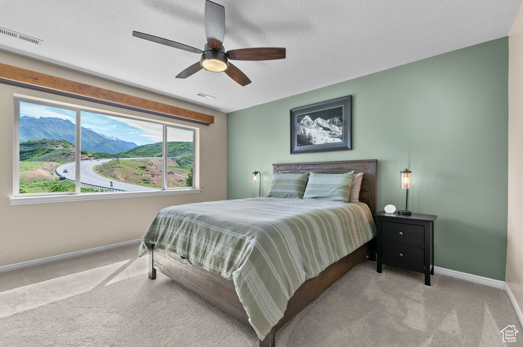 Bedroom featuring baseboards, carpet flooring, and a ceiling fan