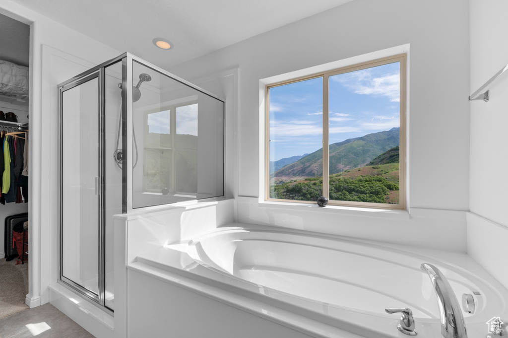 Full bath featuring a stall shower, a bath, a spacious closet, healthy amount of natural light, and recessed lighting