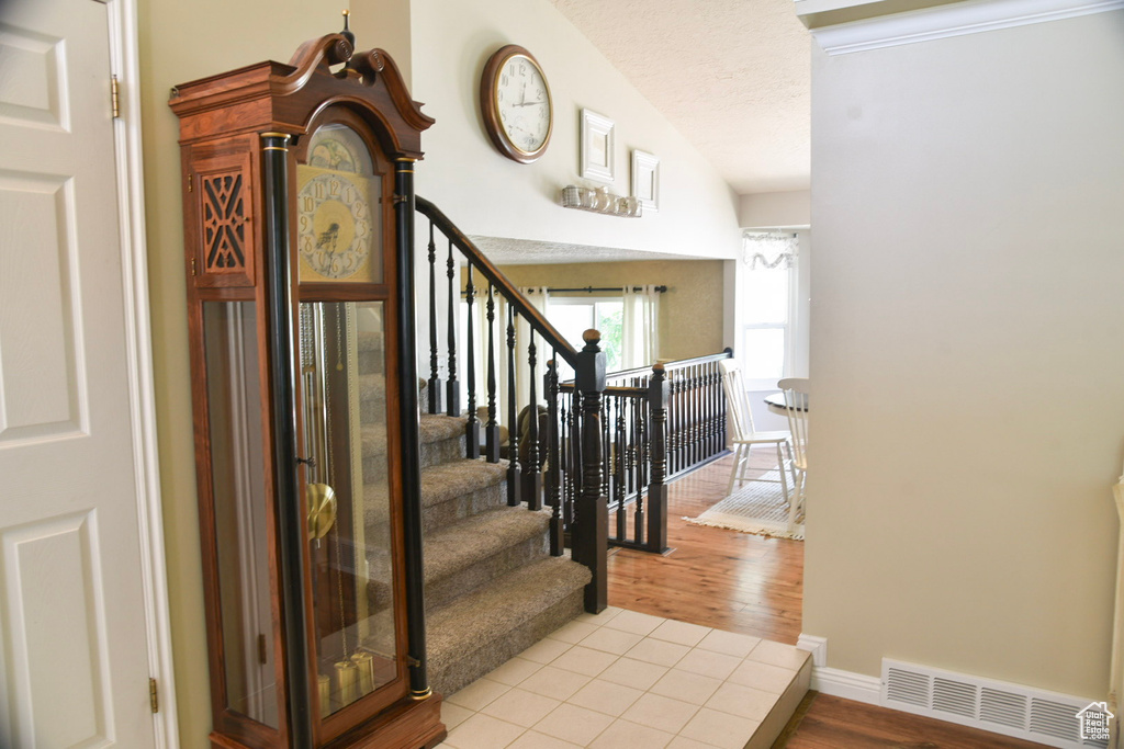 Staircase featuring wood finished floors and a textured ceiling