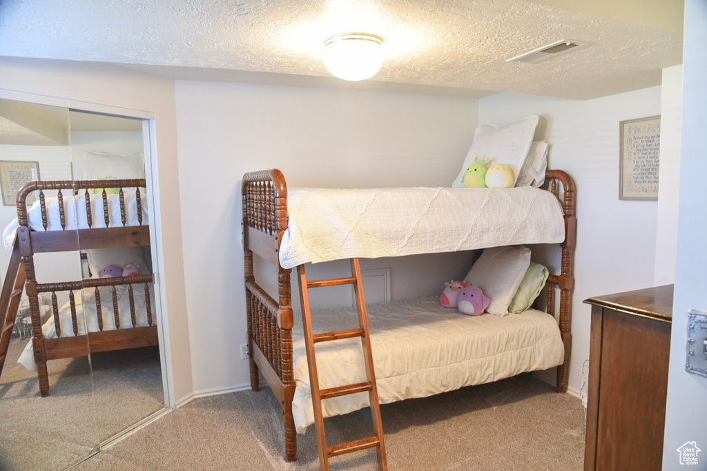 Carpeted bedroom featuring a textured ceiling