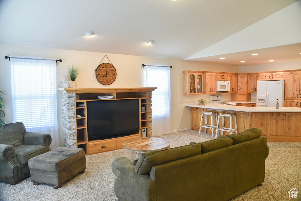 Living area featuring light colored carpet, vaulted ceiling, recessed lighting, and baseboards