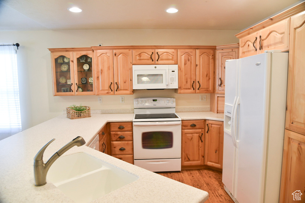 Kitchen featuring white appliances, a sink, light wood-style floors, light countertops, and recessed lighting