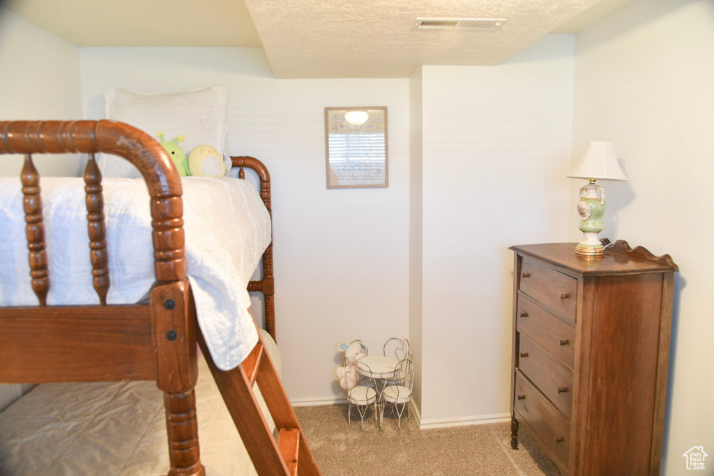 Bedroom with carpet flooring, baseboards, and a textured ceiling
