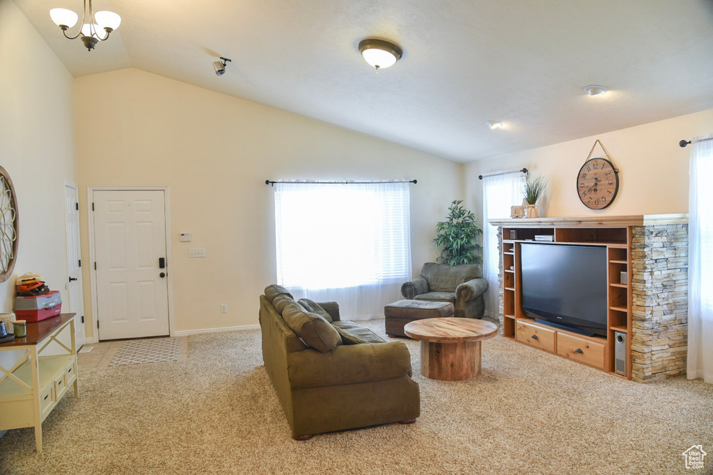 Living area featuring lofted ceiling, carpet flooring, and baseboards