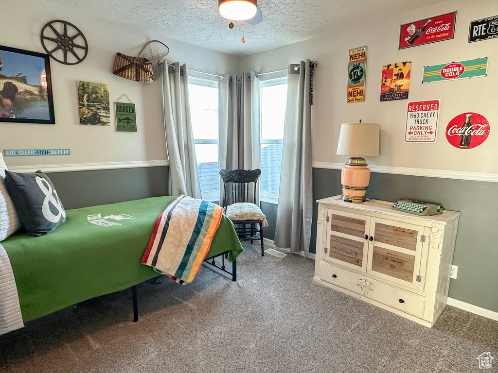 Carpeted bedroom with a textured ceiling and baseboards