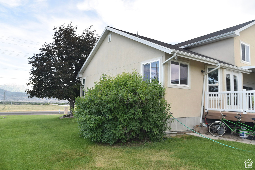 View of property exterior with stucco siding and a lawn