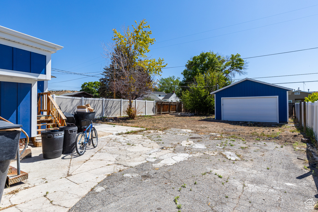 Fenced backyard with a detached garage and an outbuilding