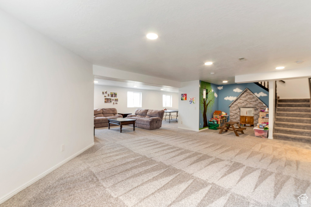 Carpeted living area featuring stairs, baseboards, and recessed lighting