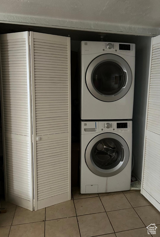 Washroom featuring estacked washer and dryer and light tile patterned floors