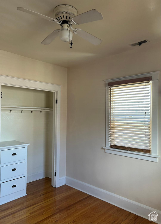 Unfurnished bedroom featuring baseboards, wood finished floors, a closet, and ceiling fan