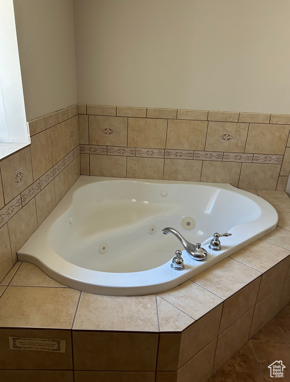 Bathroom with a jetted tub and tile patterned floors