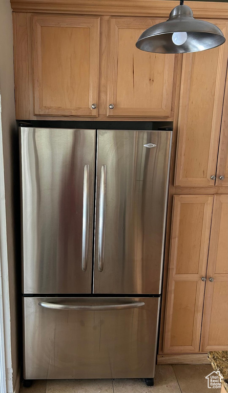 Kitchen view of freestanding refrigerator and light brown cabinets