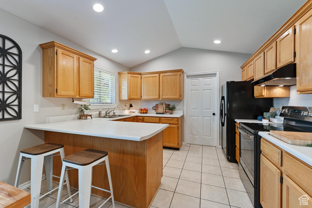 Kitchen with black electric range, under cabinet range hood, a peninsula, a sink, and lofted ceiling