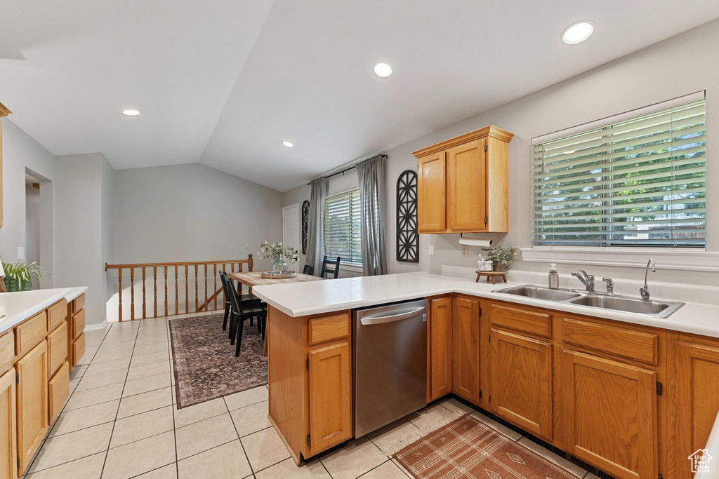 Kitchen featuring dishwasher, a sink, light countertops, a peninsula, and vaulted ceiling